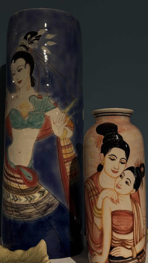 Two hand-painted ceramic vases featuring figures in traditional attire, similar to Japanese Satsuma ware.
