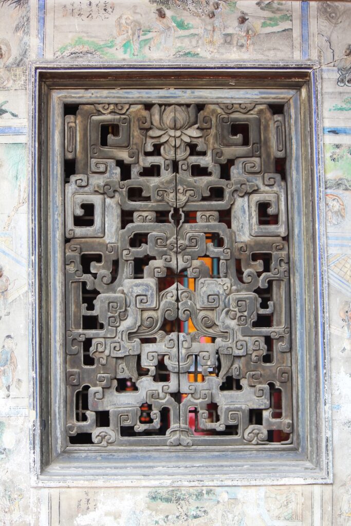 Carved wooden window at San Chao Kian An Keng, a historic Chinese shrine in Thonburi, Bangkok.