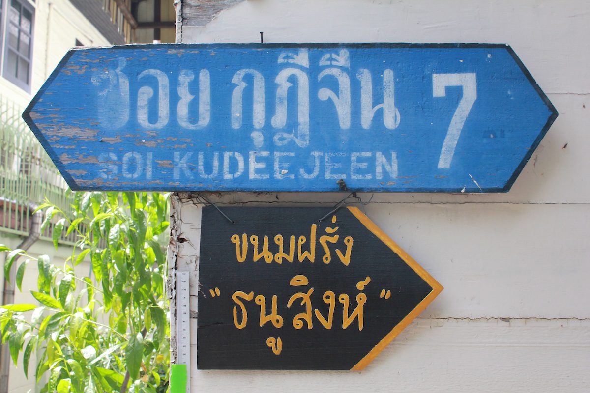 Two signs in the Kudi Chin neighborhood of Bangkok, a riverside area rich in history and cultural harmony.