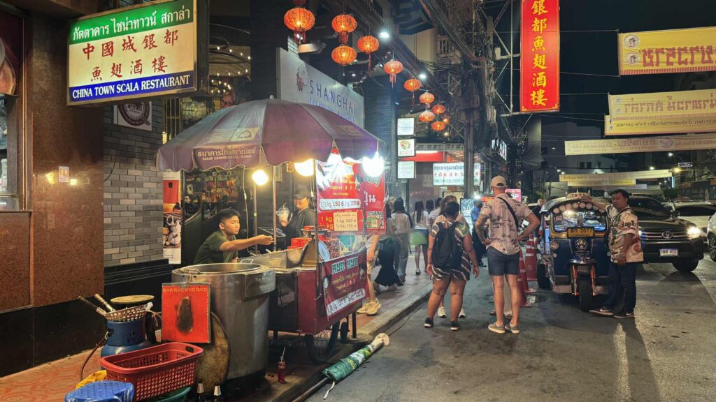 Bustling night scene in Yaowarat, Bangkok – vibrant street life with food vendors and restaurants.